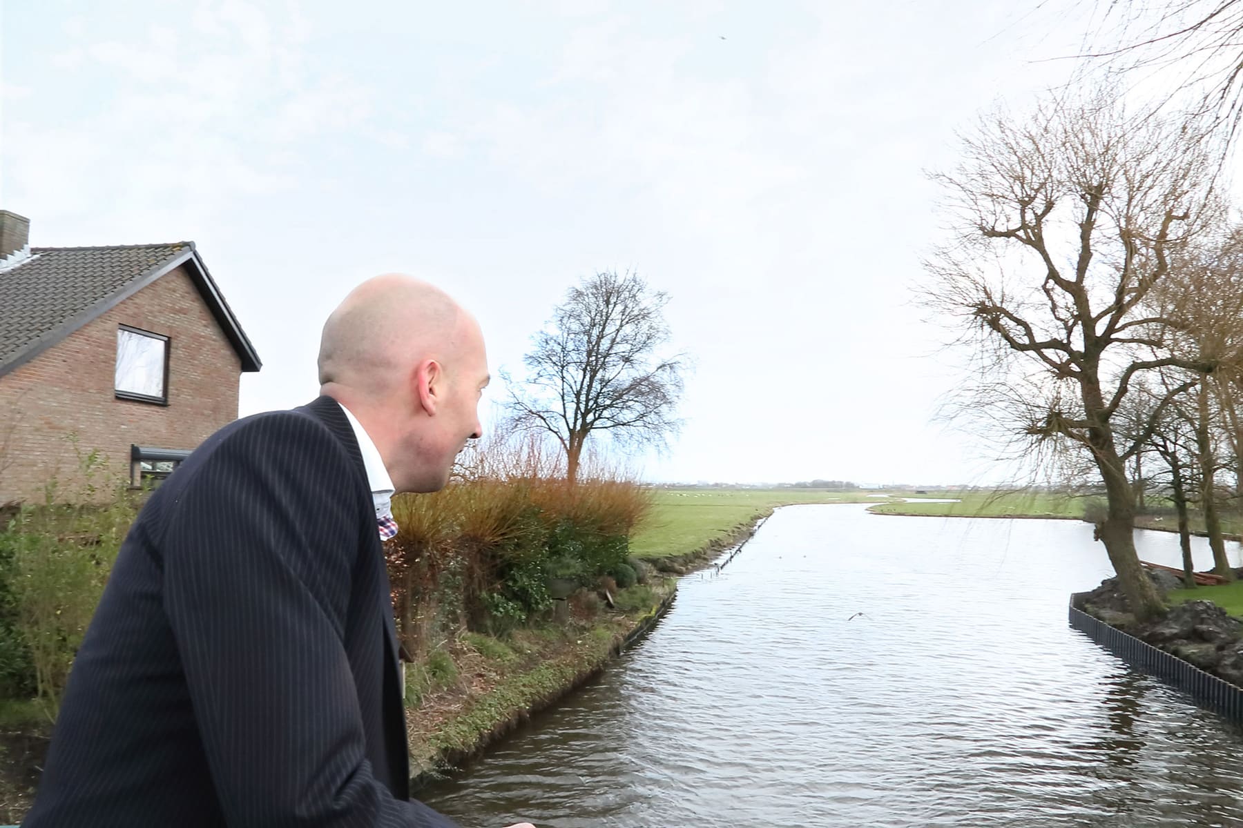 Adviseur buiten aan het water in het polderlandschap