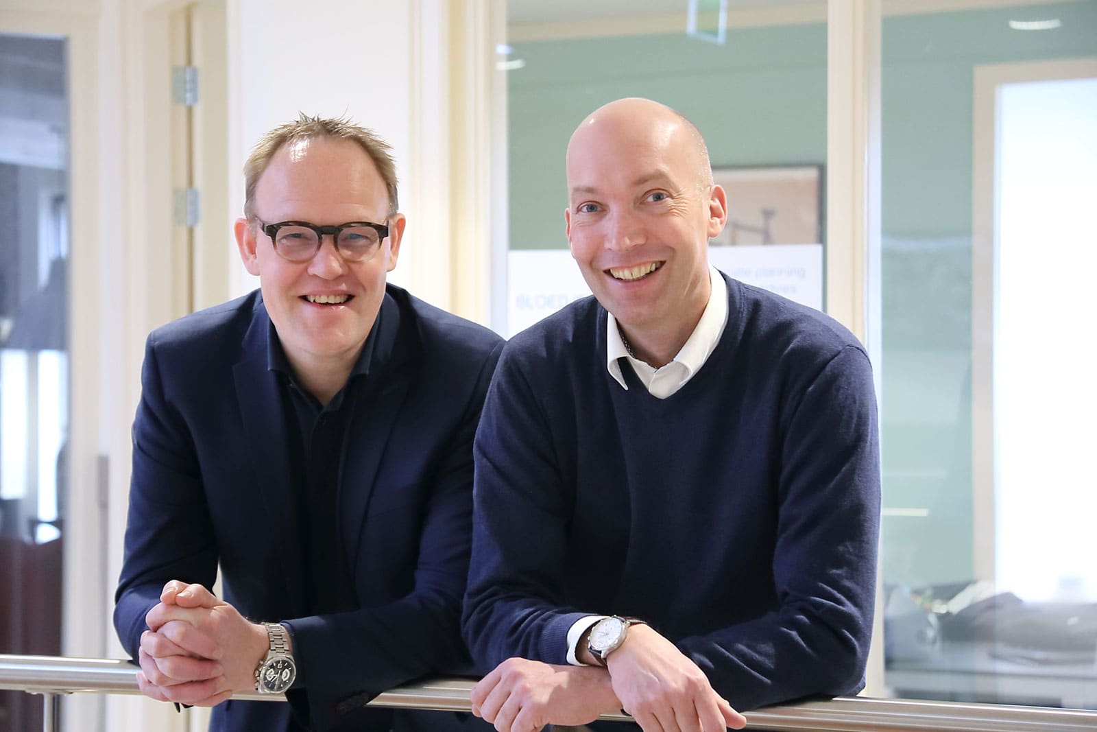 Twee adviseurs van Bloedjes & Eriks lachen samen in het kantoor